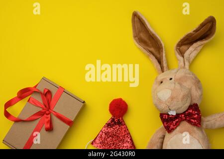 Plüsch braun Kaninchen, Geschenk in einer Box auf einem gelben Hintergrund Stockfoto