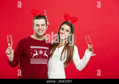 Weihnachten Konzept - glückliches junges Paar in Pullover Weihnachten feiern mit Champagner Stockfoto