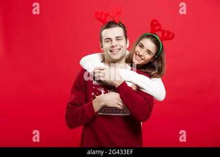 Weihnachten Konzept - Romantisches Paar in einem Weihnachten Pullover huging einander Stockfoto