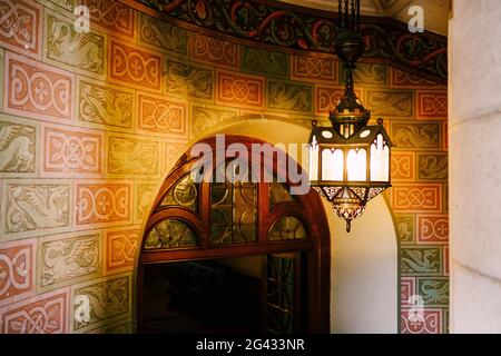 Antike Wandleuchte auf einer Wendeltreppe im Schloss Neuschwanstein. Stockfoto