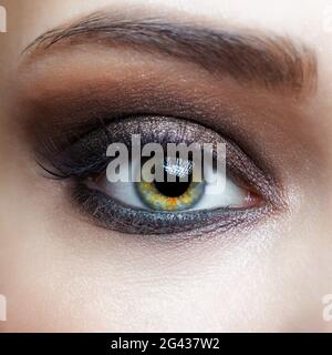 Nahaufnahme eines weiblichen menschlichen Auges mit rosa Augen, Schatten Stockfoto