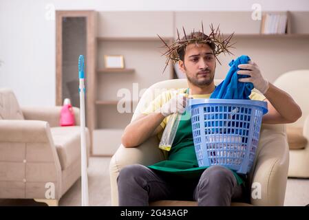 Junger männlicher Auftragnehmer trägt einen stacheligen Kranz auf dem Kopf und reinigt den Kopf Stockfoto