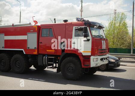 Feuerwehrauto auf der Straße. Das Auto geht, um das Feuer zu löschen. Rettungskräfte fahren auf der Autobahn, um zu helfen. Stockfoto