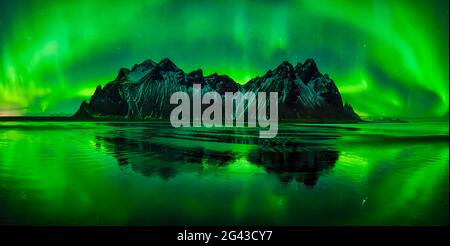 Aurora borealis über den Bergen von Vestrahorn und am nächtlichen Strand, Stokksnes, Island Stockfoto