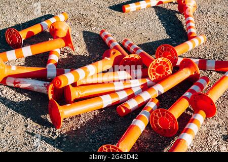 Auf der Straße sind orangefarbene Straßenbegrenzer aufgestapelt. Stockfoto