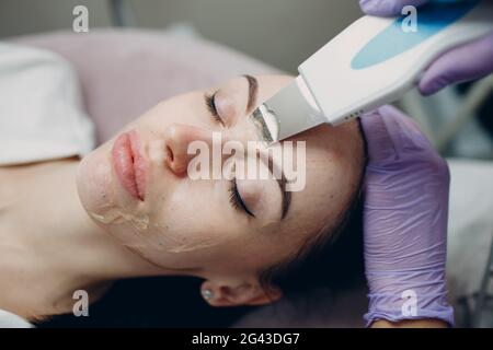 Frau, die eine Reinigungstherapie mit einem professionellen Ultraschallgerät im Kosmetikbad Cosmetology erhält Stockfoto