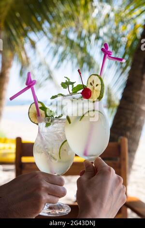 Hände mit zwei Cocktailgläsern mit frischem Limettensaft im Restaurant und in der Bar des Ancarine Beach Resort am Ong lang Beach, Ong lang, Phu Quoc Stockfoto