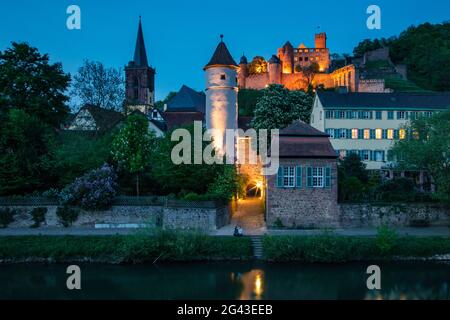 Die Tauber fliesst sanft an der Altstadt mit dem Roten Turm am Faultor (Kittsteintor), der Stiftskirche und der Burg Wertheim in der Abenddämmerung, Wertheim, Spes vorbei Stockfoto