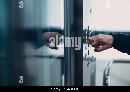 Nahaufnahme des Zeigefinger-Knöchels durch Drücken des Tastenhebels während des Coronavirus-Pandemiekonzepts covid-19-Quarantäne Stockfoto