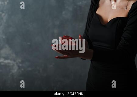 Frau in schwarzem Kleid klatscht in die Hände. Herzlichen Glückwunsch und Beifall. Stockfoto