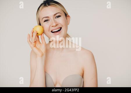 Junge schöne Frau mit Apfel in der Nähe Gesicht, Jugend und Haut Naturkosmetik Konzept Stockfoto