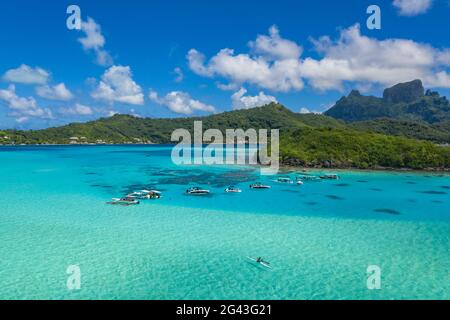 Luftaufnahme von Auslegerkanus und Ausflugsbooten in der Bora Bora Lagune, Bora Bora, Leeward Inseln, Französisch-Polynesien, Südpazifik Stockfoto