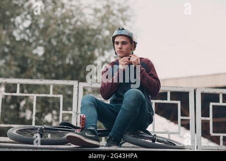Professioneller junger bmx-Sportler-Radfahrer mit bmx-Fahrrad im Skatepark. Stockfoto
