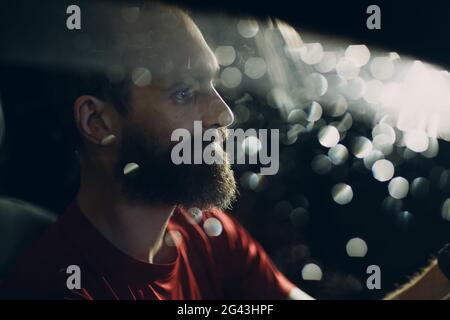 Man Fahrer sitzt am Lenkrad des Autos in der Nacht Stockfoto
