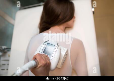 Junge schöne Frau und LPG-Massageverfahren in der Kurklinik. Lymphatische Entwässerungsmassage Flüssiggas-Apparat-Prozess. Stockfoto