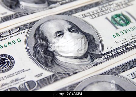 Eine 100 Dollar Geldrechnung. Benjamin Franklin mit Gesicht medizinische Maske. COVID-19 Coronavirus USA, Wirtschaft Weltkrise. Stockfoto