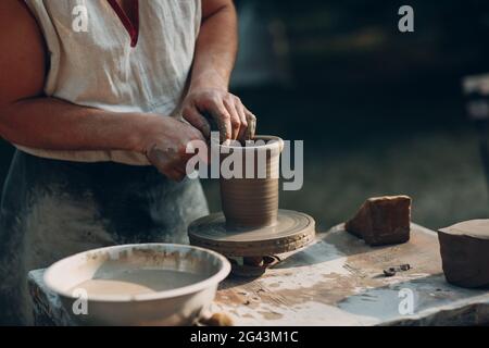 Potter macht Tontopf jar auf der Töpferscheibe Stockfoto