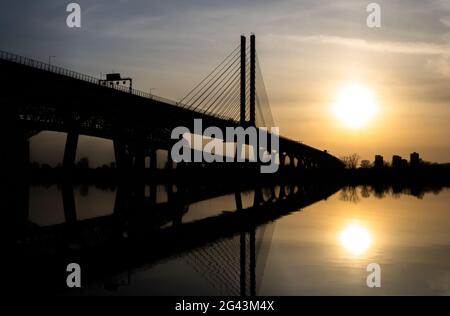 Ein wunderschöner Sonnenuntergang mit der Silhouette der Champlain-Brücke, die von Brossard nach Montreal führt. Stockfoto