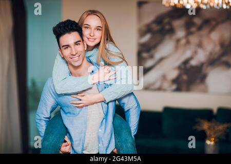 Glückliche junge Paar Familie. Positiver Mann und Frau umarmen peggyback. Umarmung und glücklich in neue Immobilien. Stockfoto