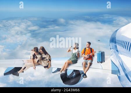 Touristen Freunde fliegen im Urlaub und sitzen auf Flügel des Jet Passagierflugzeug. Tagesflug. Stockfoto