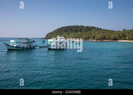 Ausflugsboote vor dem Strand mit Kokospalmen, May Rut Island, in der Nähe von Phu Quoc Island, Kien Giang, Vietnam, Asien Stockfoto