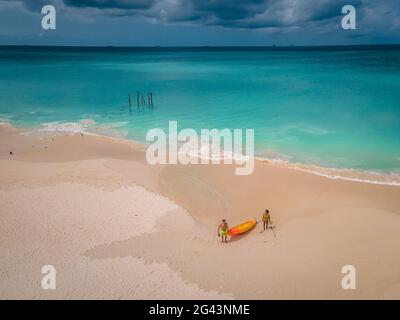 Aruba Caribbean Paar Männer und Frauen mittleren Alters im Kajak im blauen Ozean am Strand mit Palmen Stockfoto