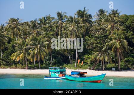 Fischerboote vor dem Strand mit Kokospalmen, May Rut Island, in der Nähe von Phu Quoc Island, Kien Giang, Vietnam, Asien Stockfoto