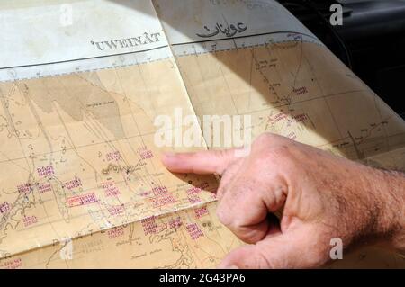 Eine Wüsten Safari Führer plant seine Route auf einer Karte des Gilf Kebir und Jebel Uweinat Gegend der Wüste Sahara in der westlichen Wüste Ägyptens. Stockfoto