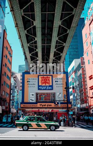 Taxi unter einer Brücke in Akihabaras Hokuriku Hauptstraße, Toyko, Japan Stockfoto