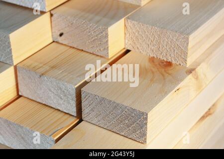 Die Holzstäbe werden in einem Stapel gestapelt. Sägen Trocknen und Vermarktung von Holz. Industrieller Hintergrund. Stockfoto