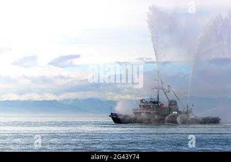 Das schwimmende Schlepper-Boot sprüht Wasserstrahlen Stockfoto