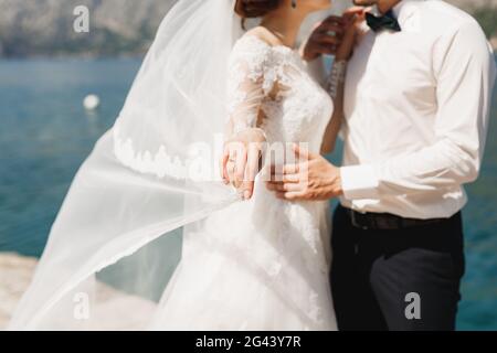 Braut und Bräutigam umarmen sich am Pier in der Bucht von Kotor Stockfoto