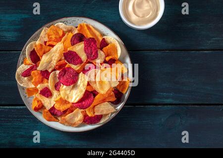 Bunte Gemüsechips mit einem hausgemachten Dip, Schuss über den Kopf Stockfoto