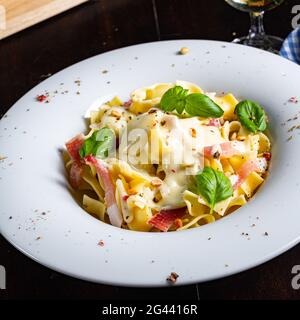 Tagliatelle mit Gorgonzola-Masarpone-Sauce und Schinken. Stockfoto