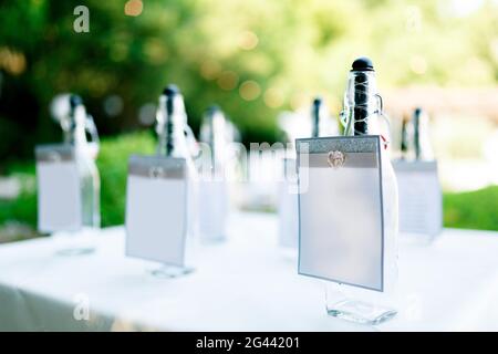 Glühende Flaschen stehen auf einem Tisch, der mit einem weißen bedeckt ist Tischdecke vor grünem Hintergrund Stockfoto