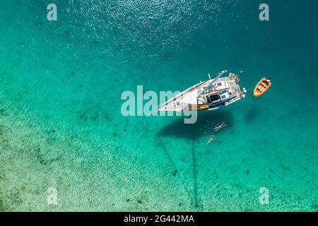 Luftaufnahme eines Paares, das von der Sandbank zu seinem Segelboot schwimmte, in der Nähe von Malolo Island, Mamanuca Group, Fidschi-Inseln, Südpazifik Stockfoto