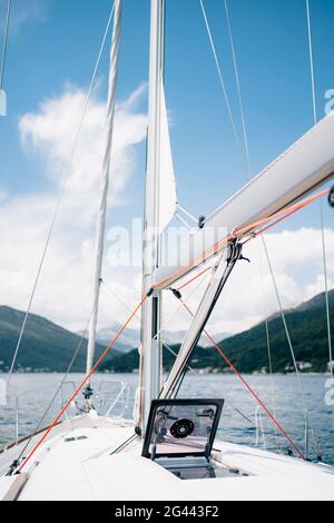 Winde aus weißer Segelyacht mit rotem Seil. Öffnen Sie die Glasluke im Bug des Schiffes Stockfoto