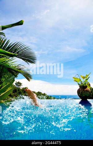 Die Füße der Frau,´s sie in einen Pool spritzt. Bali, Indonesien Stockfoto