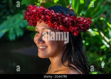 Porträt einer hübschen jungen tahitischen Frau mit Blumenkopf in den Wassergärten von Vaipahi Teva i Uta, Tahiti, Windward Islands, French Polyn Stockfoto