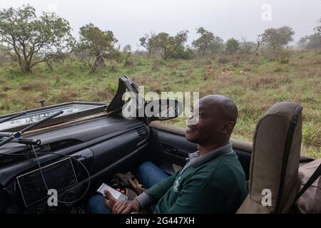 Porträt eines lächelnden ruandischen Mannes in einem Safarikfahrzeug, das vom Luxusresort Tented Magashi Camp (Wilderness Safaris), Akagera National Park, Easte, betrieben wird Stockfoto