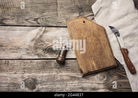 Küchenmesser aus Metall und Schneidbrett aus Holz auf einem Tisch aus Holzbrettern Stockfoto