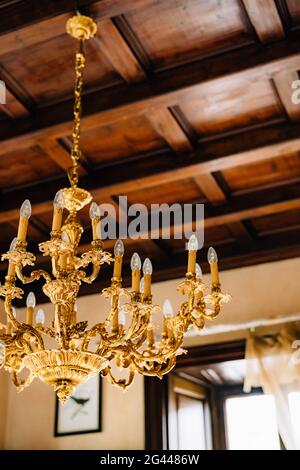 Nahaufnahme eines antiken goldenen Lüsters im Inneren einer alten Villa. Stockfoto