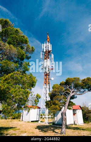 Zellenturm vor dem Hintergrund von grünen Bäumen und blau Himmel Stockfoto