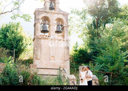 Die Braut und Bräutigam umarmen und küssen auf die alten Glockenturm in der Nähe der Kirche in Prcanj Stockfoto