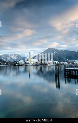 Blick über den winterlichen Tegernsee auf das Dorf Rottach-Egern mit der Kirche Sankt Laurentius, Bayern, Deutschland. Stockfoto