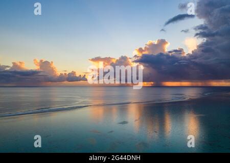 Luftaufnahme von Sonnenuntergangswolken mit Regenschauern entlang der Moorea Lagune, Avamotu, Moorea, Windward Islands, Französisch-Polynesien, Südpazifik Stockfoto