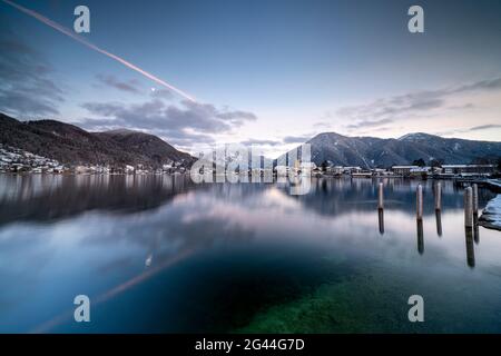 Blick über den winterlichen Tegernsee auf das Dorf Rottach-Egern mit der Kirche Sankt Laurentius, Bayern, Deutschland. Stockfoto