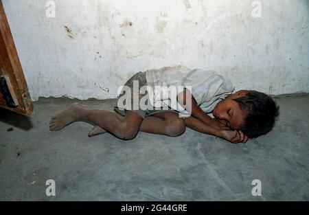 20. Mai 2002-Atambua, Indonesien-in Diese Fotos wurden am 7. Tag der Unabhängigkeit und dem Timoresischen Alltag in Dili und im Dorf Atambua aufgenommen. Ein Junge aus dem Kinderhaus schläft in der Nähe des Flüchtlingslagers in Atambua, Indonesien. Stockfoto