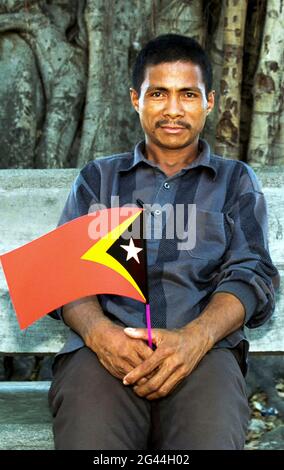 20. Mai 2002-Dili, Timor-Leste-in Diese Fotos entstanden am 7. Tag der Unabhängigkeit und dem Leben der Timoren in Dili und im Dorf Atambua. Ein Mann hält seine Nationalflagge im Park in Dili, Timor-Leste. Stockfoto