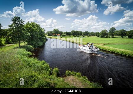 Der Ems-Jade-Kanal mit Motorboot in Reepsholt, Friedeburg, Wittmund, Ostfriesland, Niedersachsen, Deutschland, Europa Stockfoto